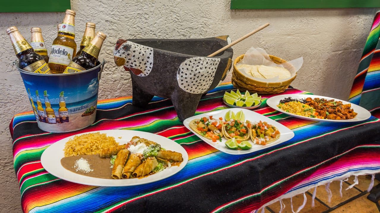 Plates of Mexican dishes with tequila and mezcal